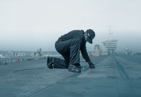 man repairing navy ship